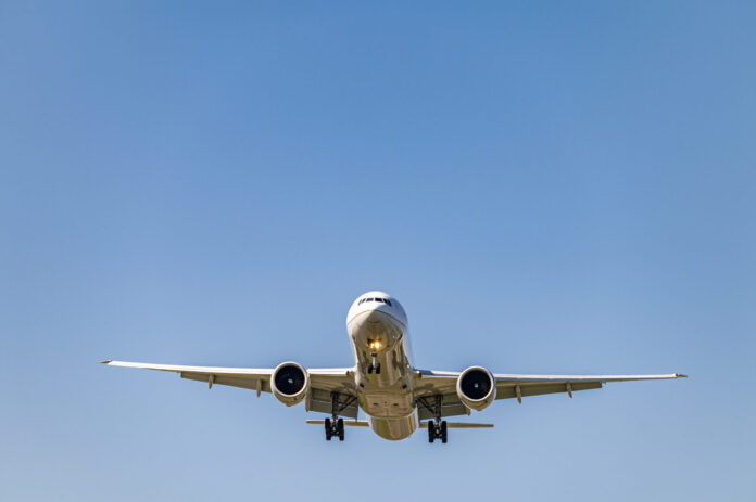 Low angle shot airplane flying closer daytime scaled
